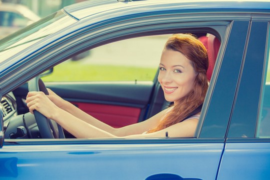 happy woman driving car after automotive service